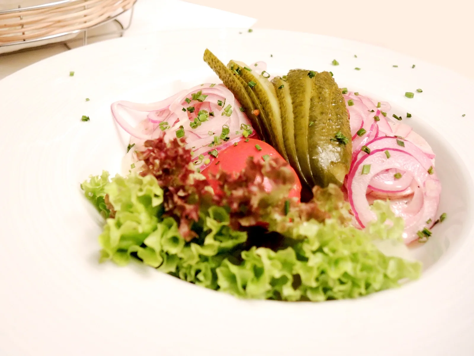 Frisch angerichtete Vorspeise mit Salat, Gurke und roten Zwiebeln