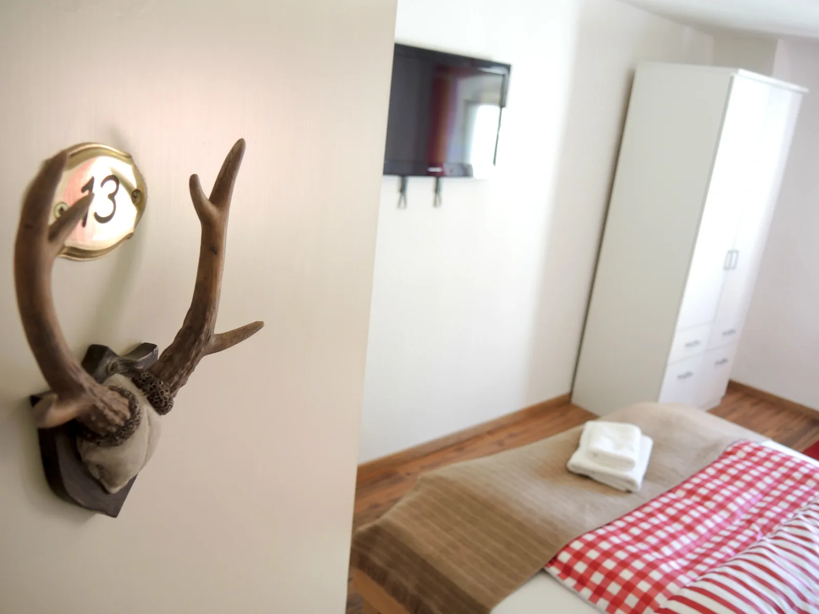 Zimmer mit bayerischem Ambiente und rot-weißer Bettwäsche